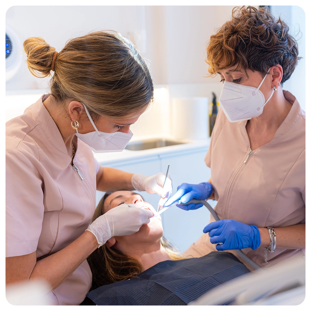 Dentist and assistant performing a filling on a tooth for a client in the modern dental clinic