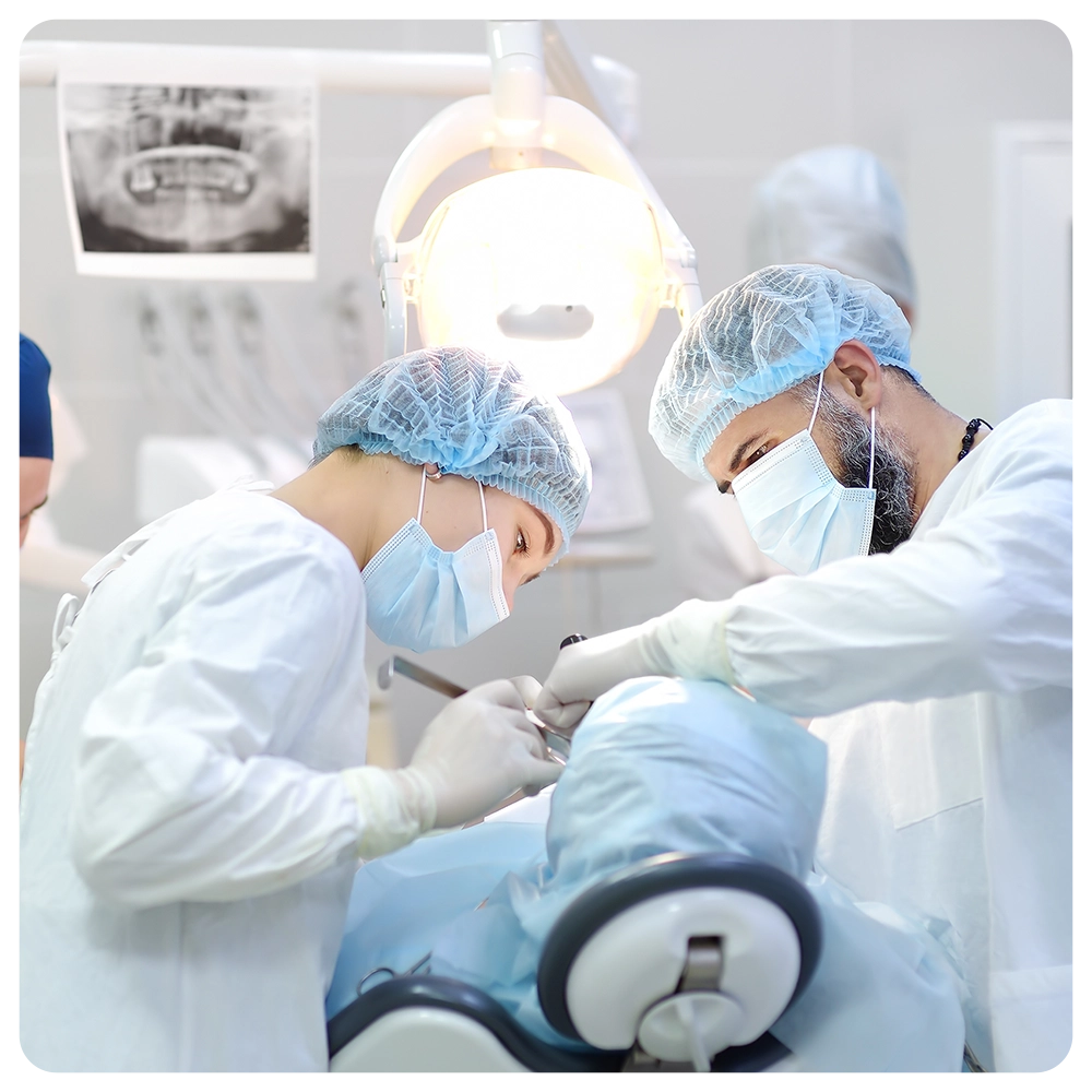 Surgeon and nurse during a dental operation.Anesthetized patient in the operating room
