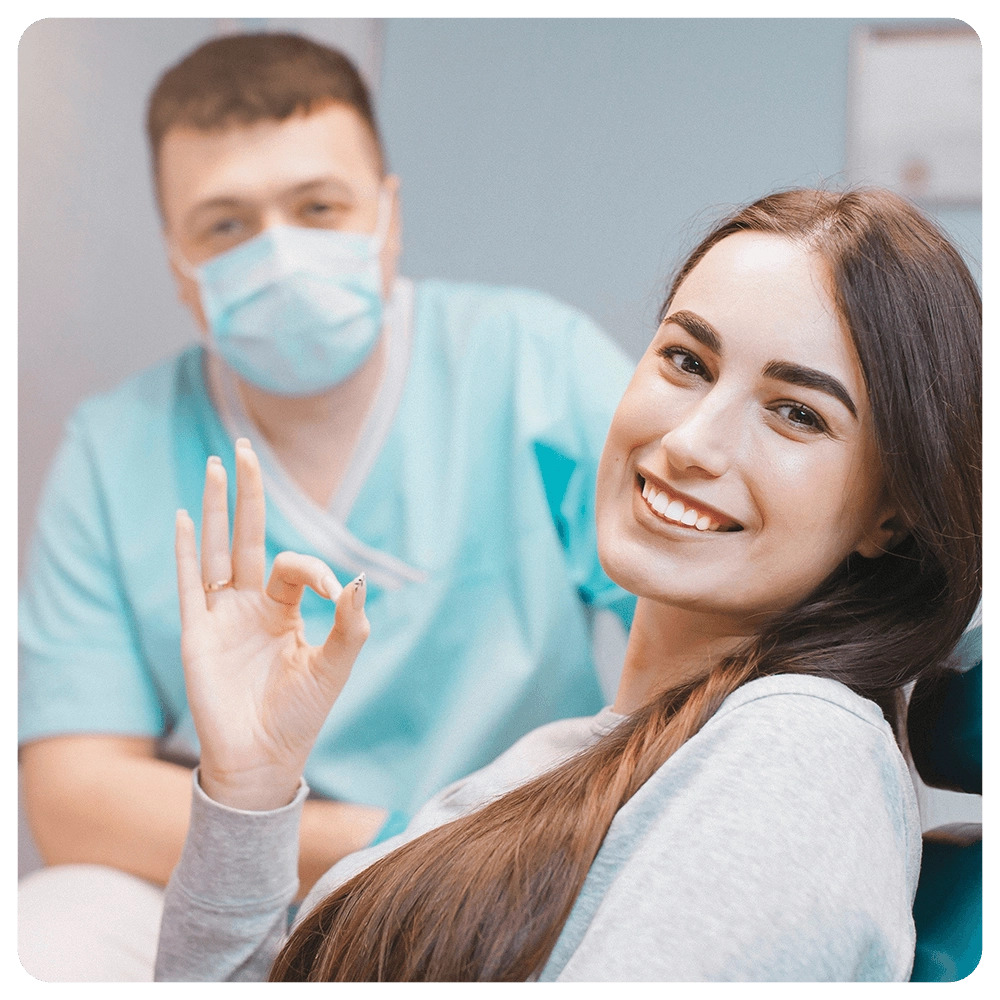 Happy patient giving the "OK" sign after dental appointment.