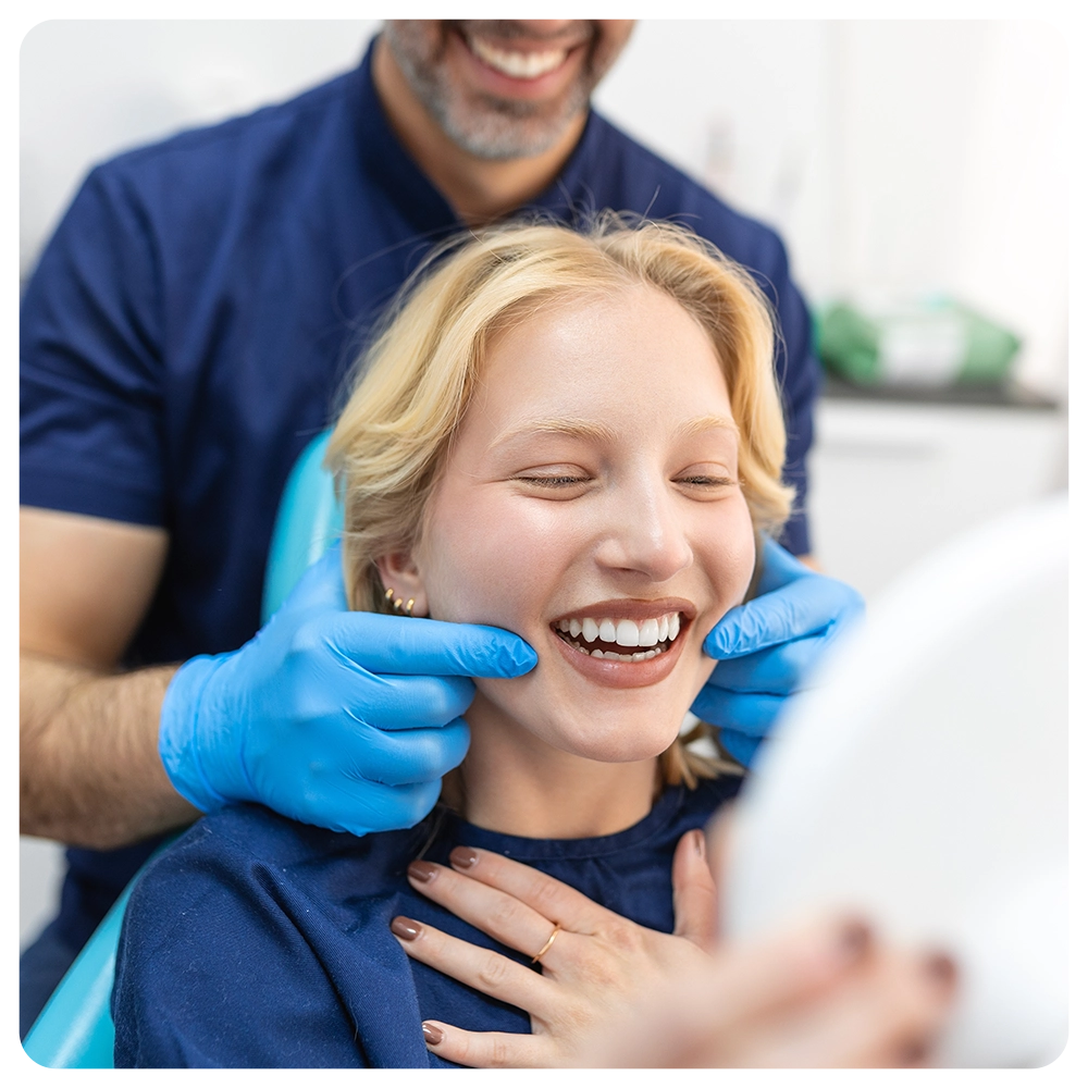 young woman checking her results in the dentists office