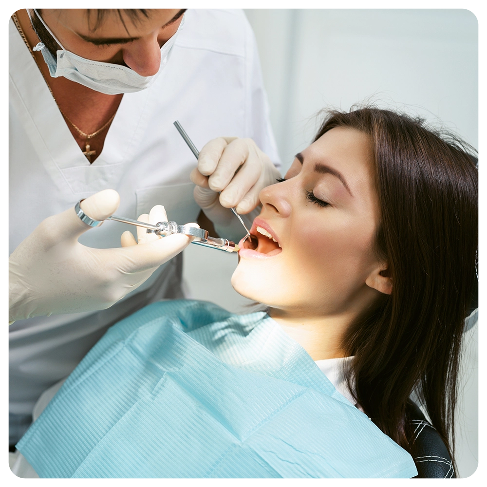 Painkiller anesthesia injection. Dentist examining a patient's teeth in modern dentistry office. Closeup cropped picture with copyspace. Doctor in disposable medical facial mask.
