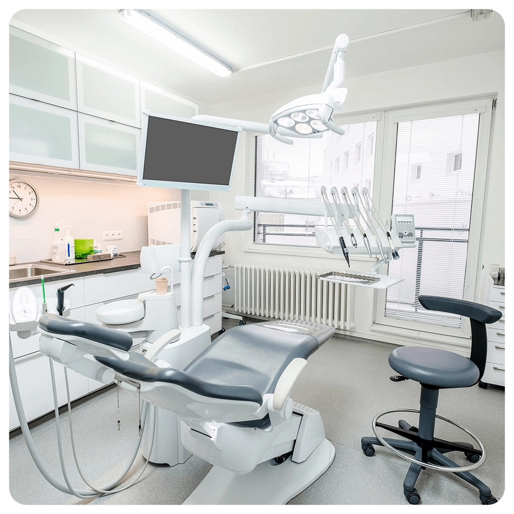 Modern dental operatory with chair, equipment, and dentist's stool.