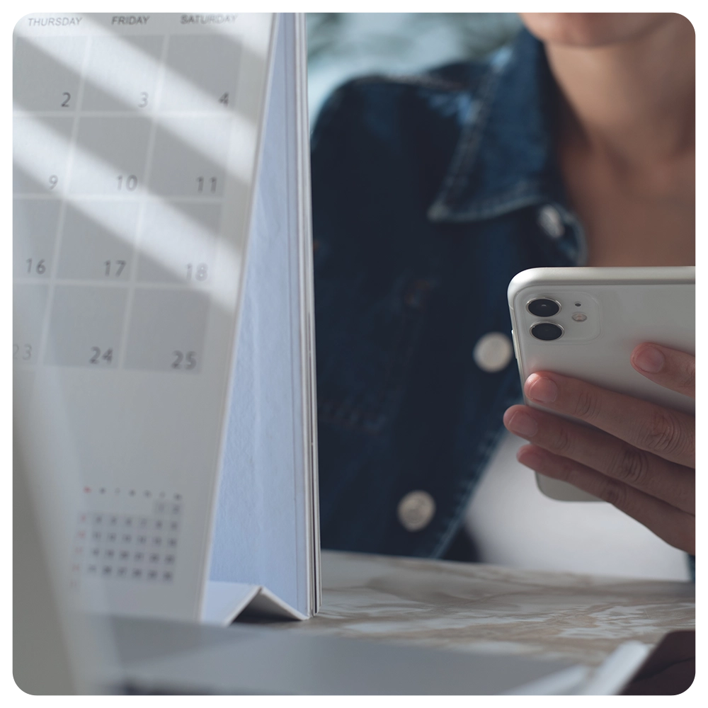 Event planner timetable agenda plan on schedule event. Business woman checking planner on mobile phone, taking note on calendar desk on office table
