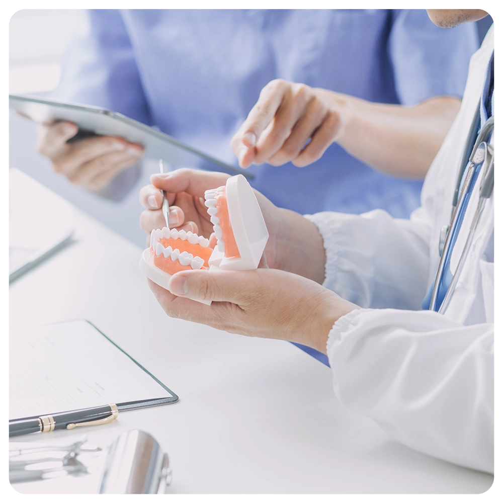 Dentists are discussing dental problems at report x-ray image on laptop screen to patients.