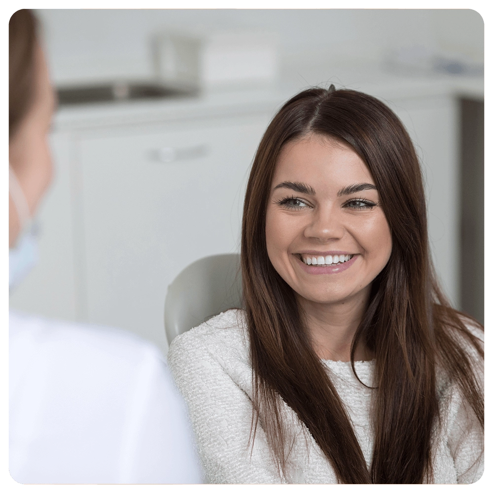 Smiling woman at a dental appointment, seated in a clinic