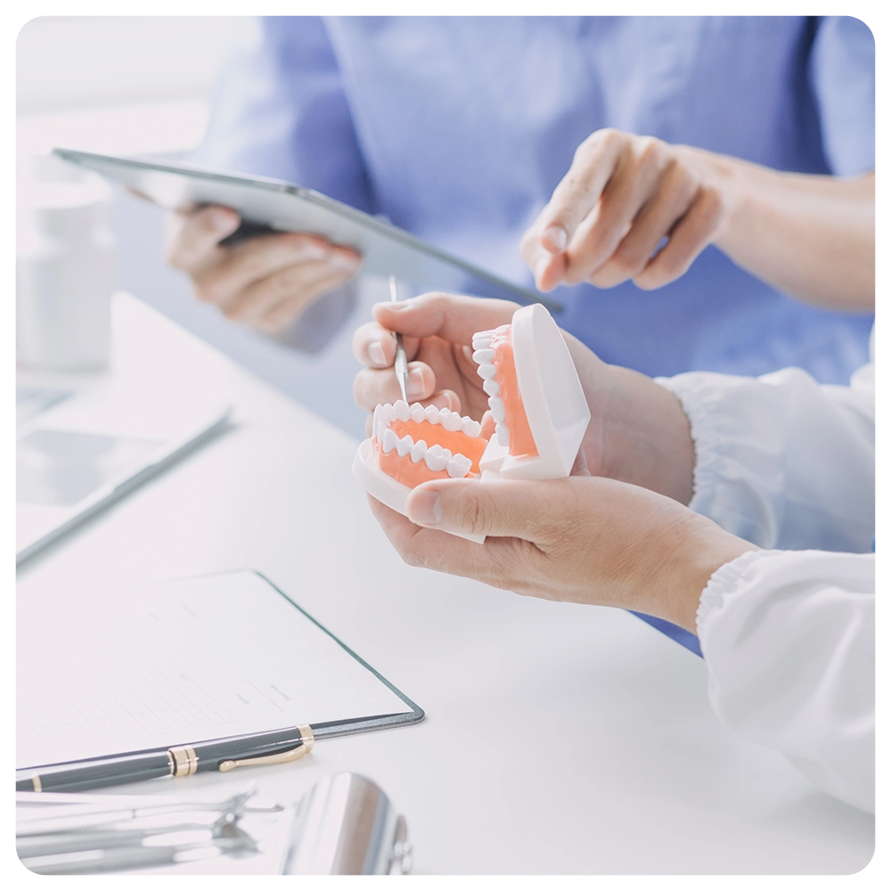 Dentists are discussing dental problems at report x-ray image on laptop screen to patients.