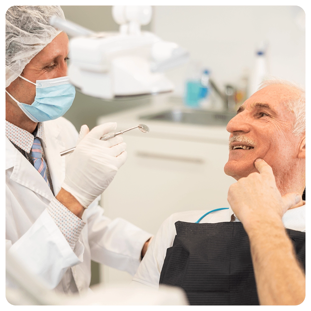Dentist examining senior patient's teeth with a mouth mirror