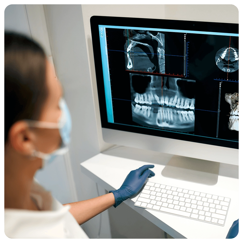 Dentist examining dental X-rays on a computer monitor