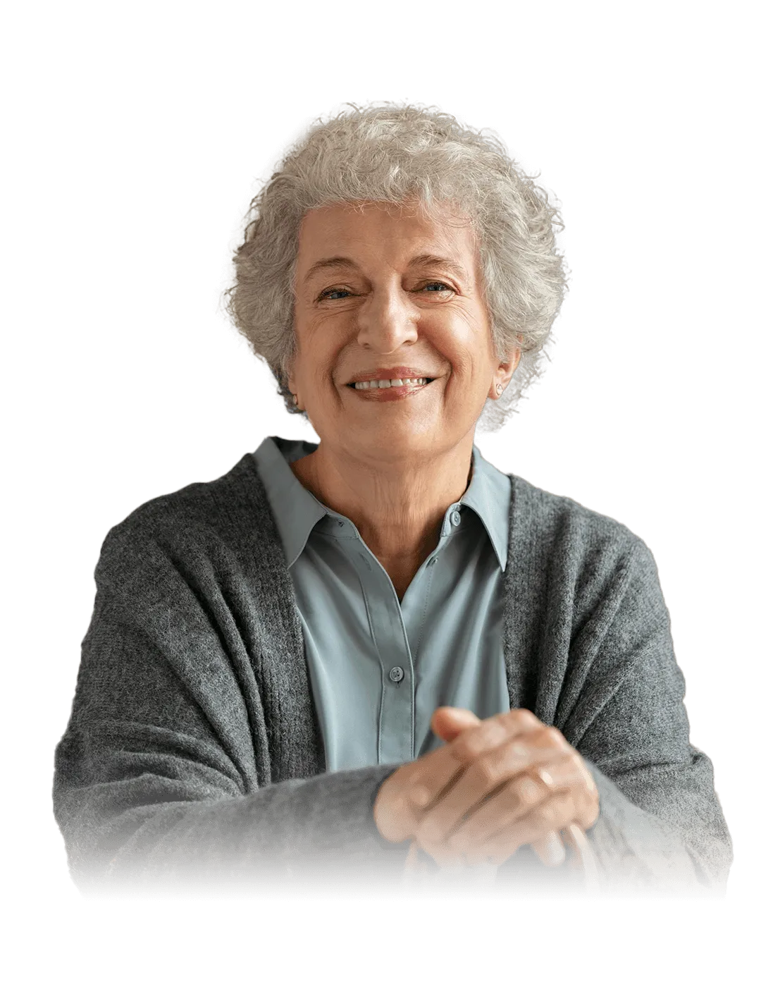 An older woman with gray curly hair smiles warmly, wearing a gray cardigan over a light blue shirt, sitting with her hands resting on a cane, against a geometric black and blue patterned background.